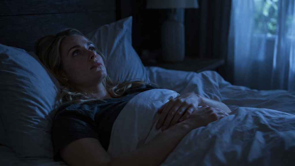 woman lying awake in bed at night with anxiety unable to sleep